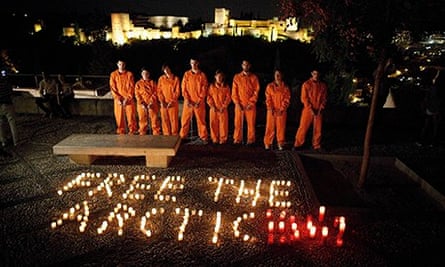 Greenpeace activists in prison uniforms stage a protest in front of the Alhambra in Granada