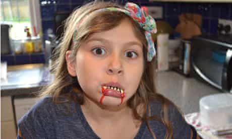 Fake blood: child with fake vampire fangs and blood