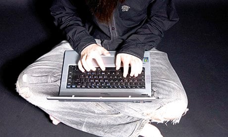 Young boy aged 16 sat down in casual clothes on a laptop computer