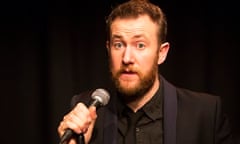 Comic Alex Horne on stage with microphone