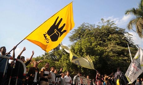 Students of Cairo University, who are supporters of the Morsi, wave a flag bearing the Rabaa sign