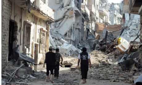 Free Syrian Army fighters walk on rubble of damaged buildings in Juret al-Shayah in Homs
