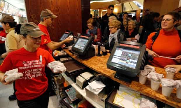 McDonald's staff members serve hamburgers at their fast food restaurant downtown Milan