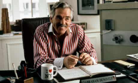 Dennis Farina smiling behind a desk in Snatch