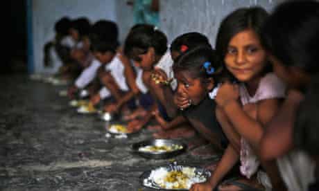 Schoolchildren eat their free midday meal at a primary school in India