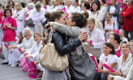 Two women kiss in front of people taking part in a demonstration against gay marriage