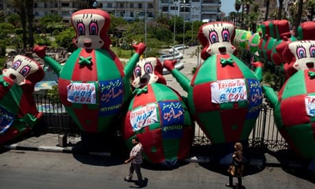 Large inflated cartoon animals bearing signs saying 'Revolution. Not a coup' in Port Said, Egypt