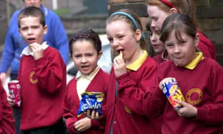Schoolchildren eating crisps