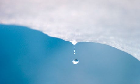 A drop of water falls from a melting piece of ice
