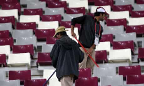 Asian workers cleaning the stadium at the end of the 2011 Asian Cup semi-final