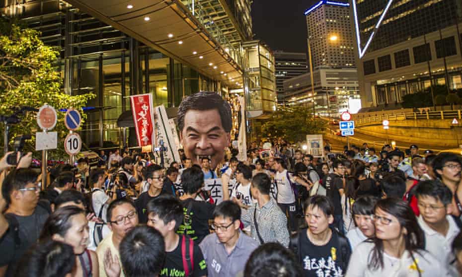 Public enemy No 1 … pro-democracy protestors march towards Government House in Hong Kong, holding a 