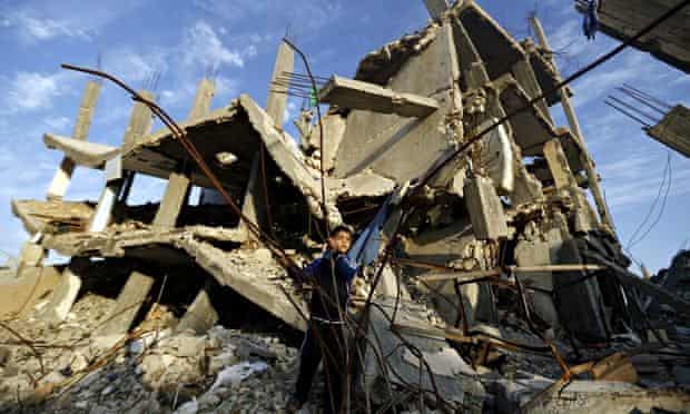 A Palestinian boy plays in the rubble of a house destroyed during clashes between Israel and Hamas