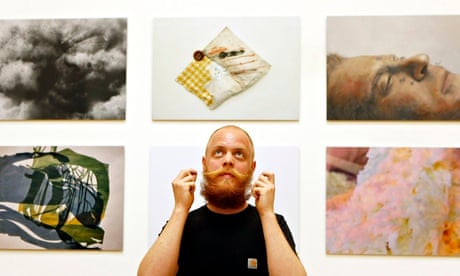 Man standing in front of photographs of art
