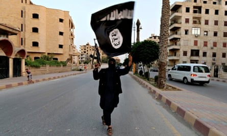 A member loyal to the Islamic State in Iraq and the Levant (ISIS) waves an ISIS flag in Raqqa