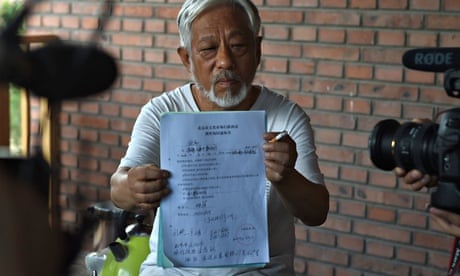 Li Xianting, Beijing independent film festival organiser, holds document up to the cameras