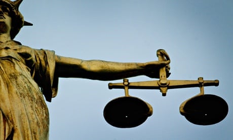 A statue holding the scales of justice is seen on top of the Old Bailey, London