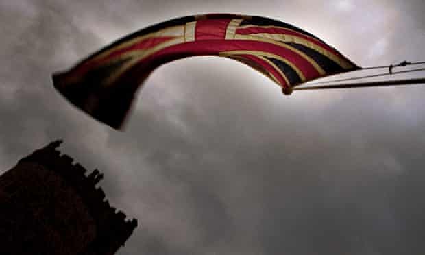 A Union Jack flag flying against stormy skies at Windsor Castle