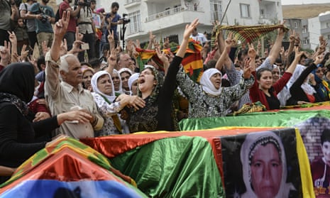 Coffins are draped in the Kurdish flag,
