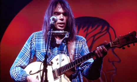 Neil Young performing on stage at the Rainbow Theatre in London in 1973
