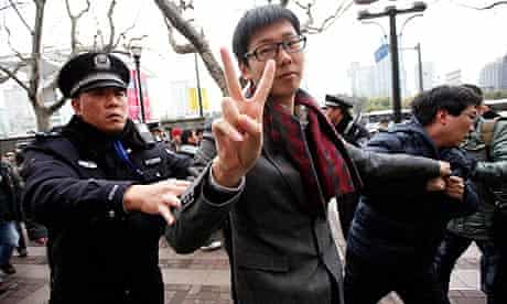 A man gestures as Shanghai police break up Jasmine Revolution protests inspired by the Arab spring