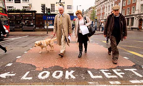 London mayoral candidate Ken Livingstone (L) walks his dog Coco as he meets voters in north London