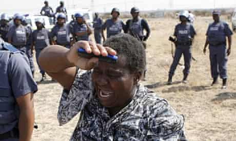 A woman cries as she confronts police at a protest over the killing of 34 miners at the Lonmin mine