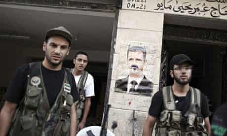 Syrian rebels before a poster of President Bashar al-Assad made into a devil caricature in Aleppo