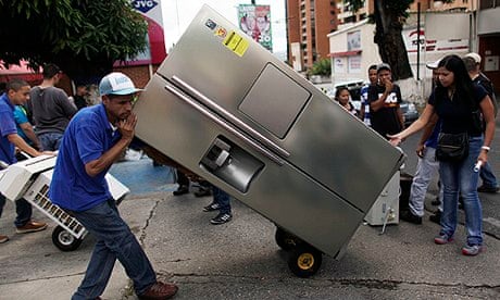 A man moves a fridge he bought in Caracas after President Maduro took over shops to ease shortages