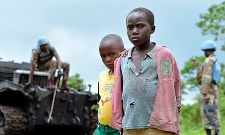 Children by a burnt-out tank abandoned by M23 rebels in Kimbumba as UN took control of east Congo