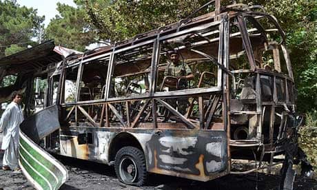 Pakistani police inspect a student bus bombed by Sunni Islamist militants