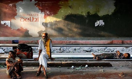 Indians waiting for a bus in Delhi in front of an ad for the city.