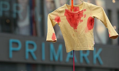 A Blockupy campaigner Holds Up a blood-stained shirt at a protest at a Primark store in Frankfurt