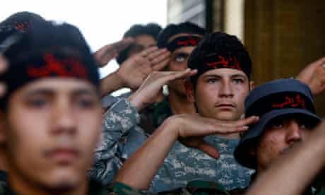 Iraqi Shia fighters salute the shrine of Sayyida Zeinab in Damascus. 