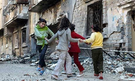 Children play in front of their homes in Khaldiyeh district in Homs