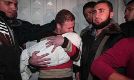 Jihad Misharawi holds the body of his 11-month son, Ahmad