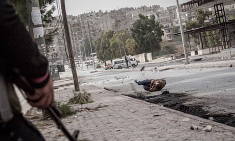 A Syrian civilian falls down on the street after being shot in his stomac