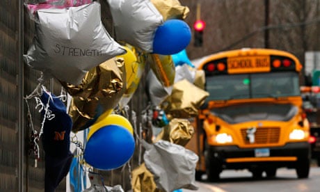 A school bus rolls towards a memorial for victims of the school shooting in Newtown