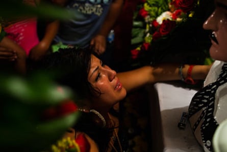 A young woman weeps in front of a bust of Jesús Malverde in Culiacán, Sinaloa