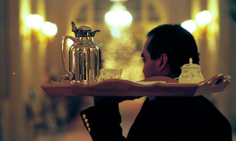 A waiter carrying a tray of tea