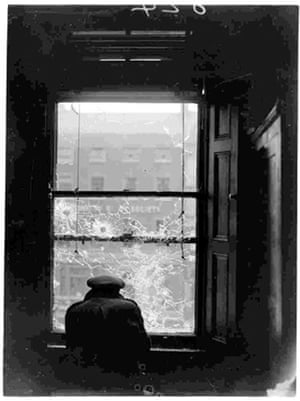Press photography: An Irish Free State soldier crouches behind a window in Dublin, 1922