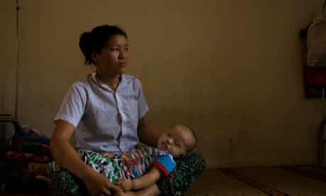 A woman waits with her baby to see a doctor at a clinic in Hoa Binh province