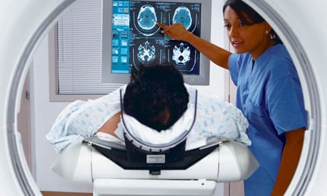 Patient in MRI scanner with Indian nurse explaining scan