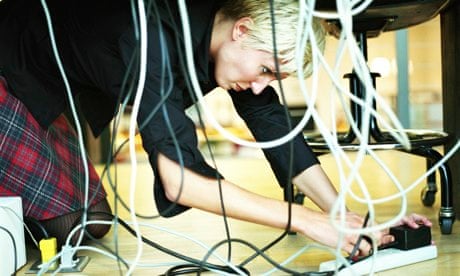 Young woman fixing power connections under desk