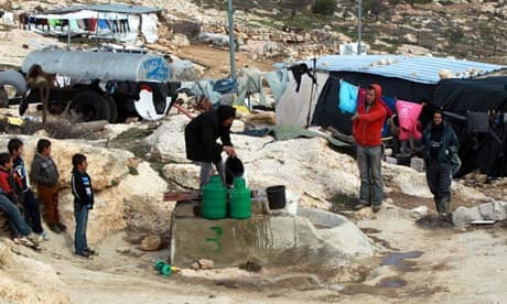 Palestinians fill water canisters from a well in the southern West Bank village of Yatta