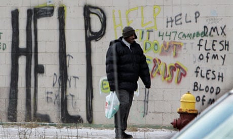 A pedestrian walks by graffiti in downtown Detroit. 