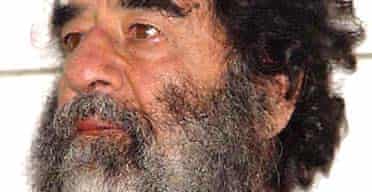 A photo of Saddam Hussein after his capture is shown during a press conference in Baghdad