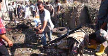 Iraqis sort through the wreckage and carry away the dead from the scene of an explosion in central Baghdad