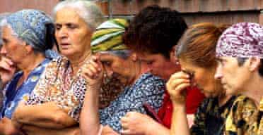 Women wait for news from the school seized by attackers in North Ossetia