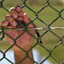 A detainee holds his praying beads while standing outside his cell in Camp Delta at the Guantánamo Bay naval base 