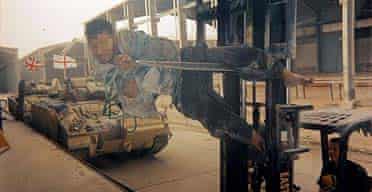 Photograph number nine of a set of 22 showing Lance Corporal Mark Cooley driving a fork lift truck with an Iraqi detainee bound to it